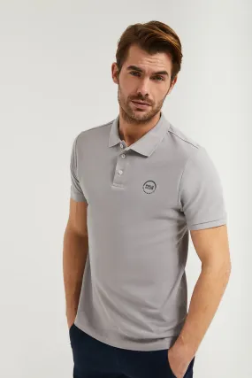 Polo gris piqué con tapeta de tres botones y logo engomado