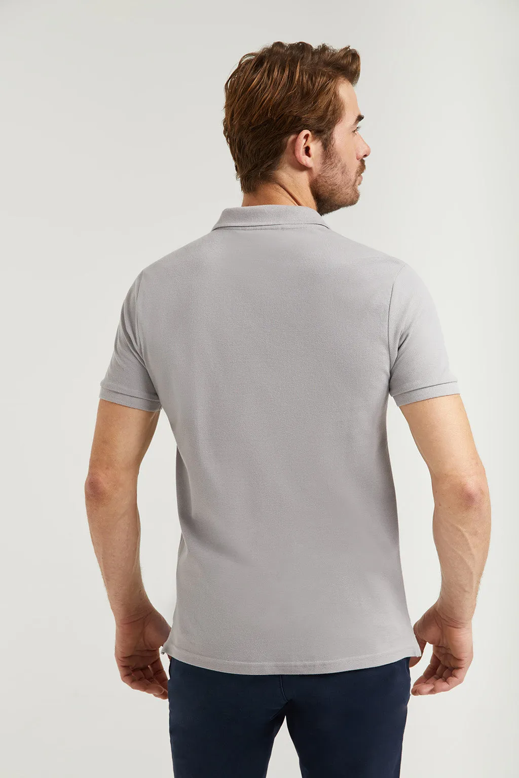 Polo gris piqué con tapeta de tres botones y logo engomado